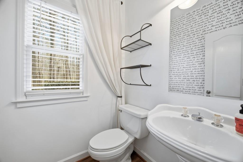 1287 Harris Commons Place Roswell, GA 30076 - Photo 12 of 25 a white toilet sitting next to a bathroom sink