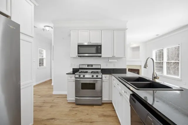 a view of a kitchen with granite countertop a sink and a stove