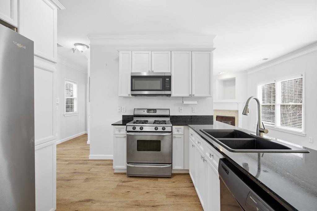 1287 Harris Commons Place Roswell, GA 30076 - Photo 10 of 25 a kitchen with stainless steel appliances granite countertop a stove a sink and a microwave