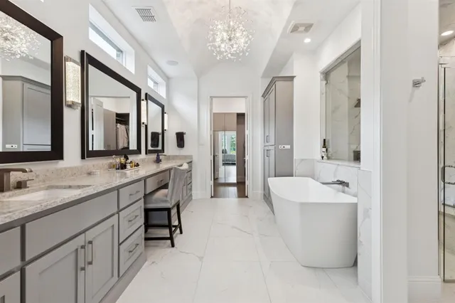 a spacious bathroom with a double vanity sink mirror and bathtub