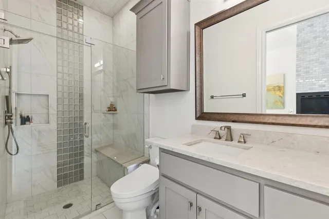 a bathroom with a sink a toilet and shower