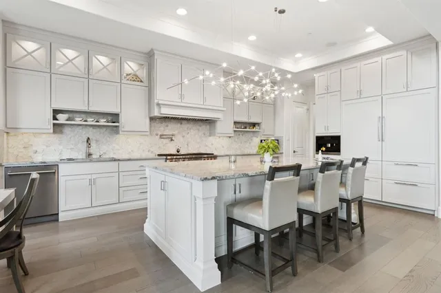 a kitchen with kitchen island granite countertop a sink cabinets and stainless steel appliances