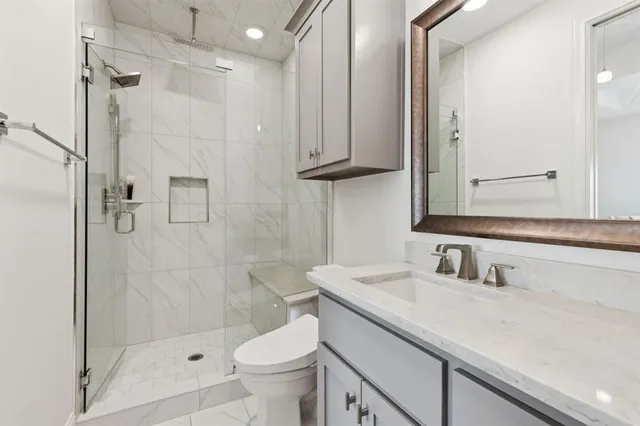 a bathroom with a sink a toilet and shower