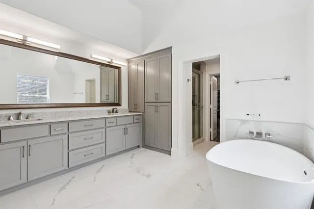 a spacious bathroom with a tub sink and mirror