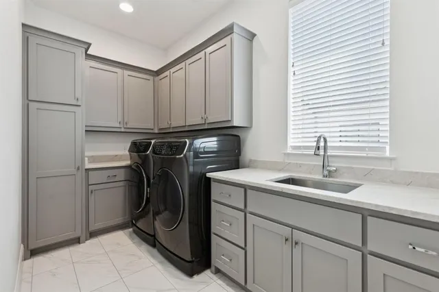 a utility room with sink dryer and washer