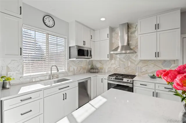 a kitchen with stainless steel appliances granite countertop a sink a stove a refrigerator and cabinets