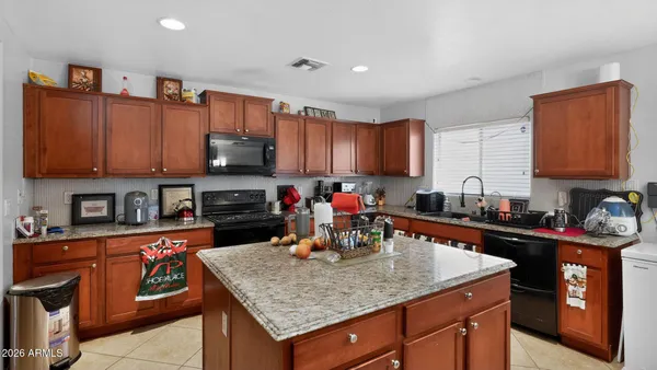 a kitchen with stainless steel appliances granite countertop a stove sink and cabinets