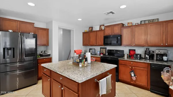 a kitchen with stainless steel appliances granite countertop a refrigerator a stove a sink and a microwave