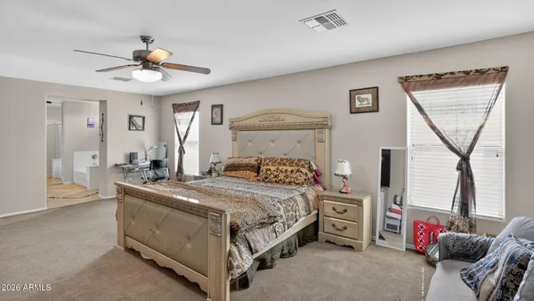 a bedroom with a bed a chandelier and a window
