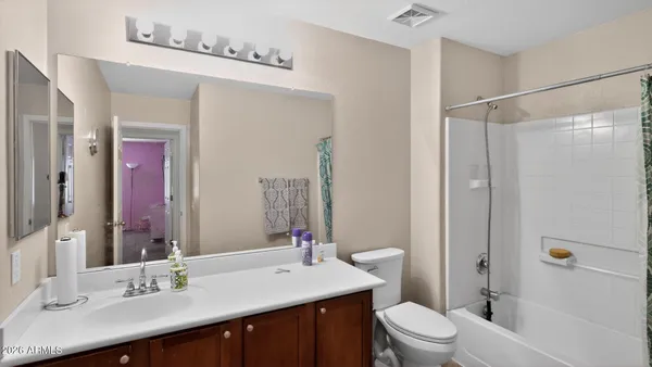 a bathroom with a sink a toilet a mirror and shower