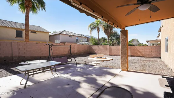a backyard of a house with table and chairs