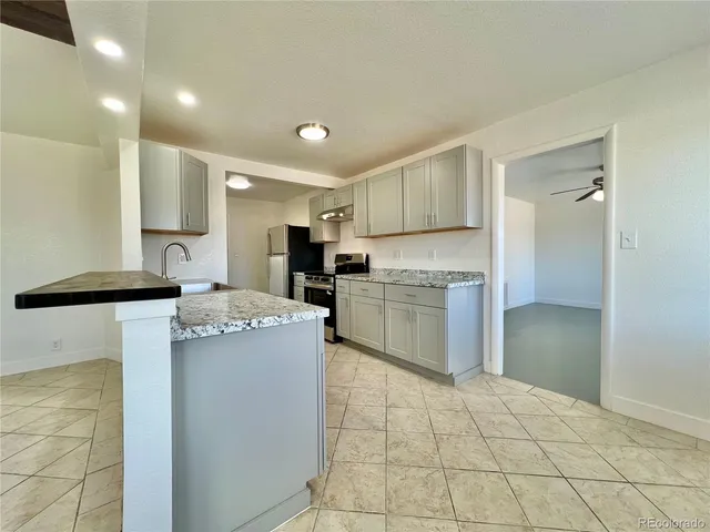 a kitchen with a stove a sink and a refrigerator