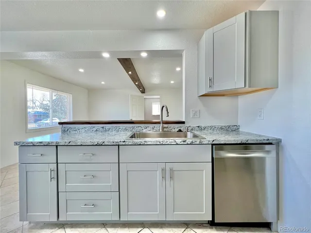 a kitchen with granite countertop a sink and cabinets