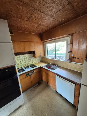 a kitchen with stainless steel appliances granite countertop a sink and a stove