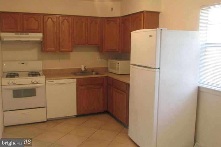 8024 Sandy Spring Road Laurel, MD 20707 - Photo 5 of 21 a white refrigerator freezer sitting inside of a kitchen