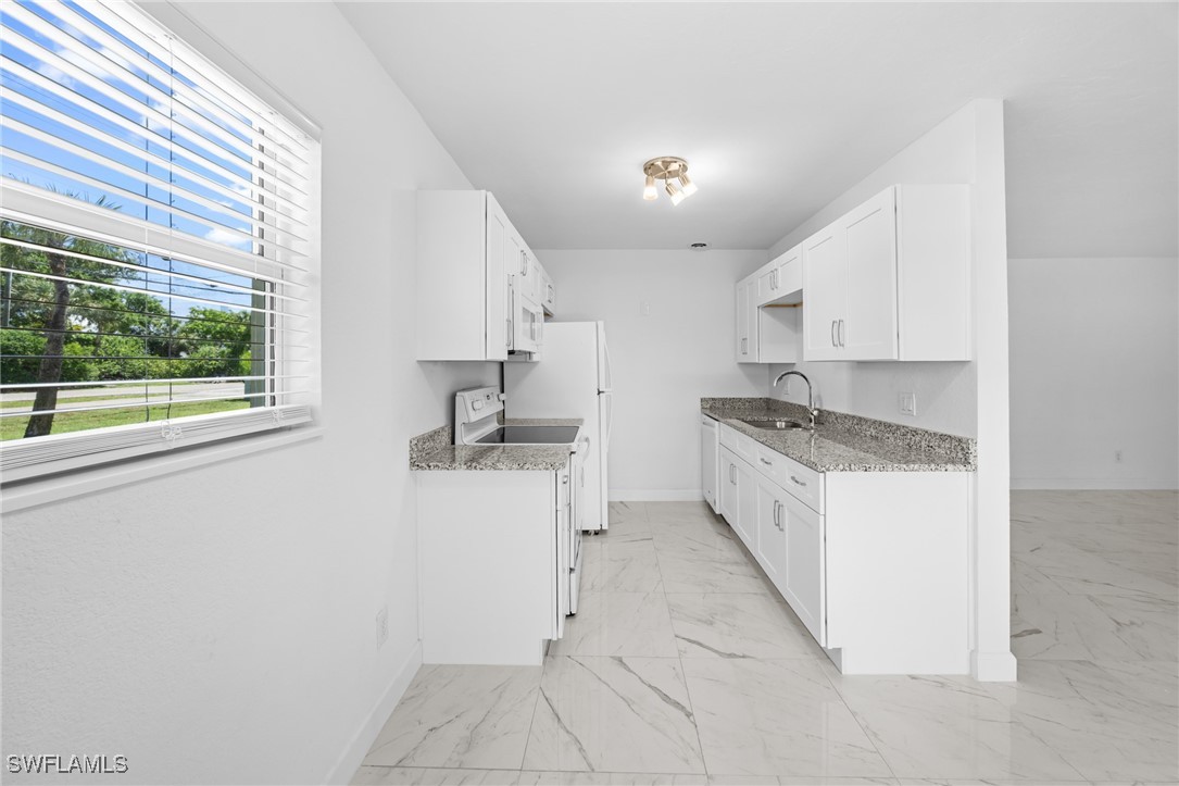 601 Periwinkle Way, Unit D1 Sanibel, FL 33957 - Photo 6 of 25 a kitchen with a refrigerator a stove a sink and a window