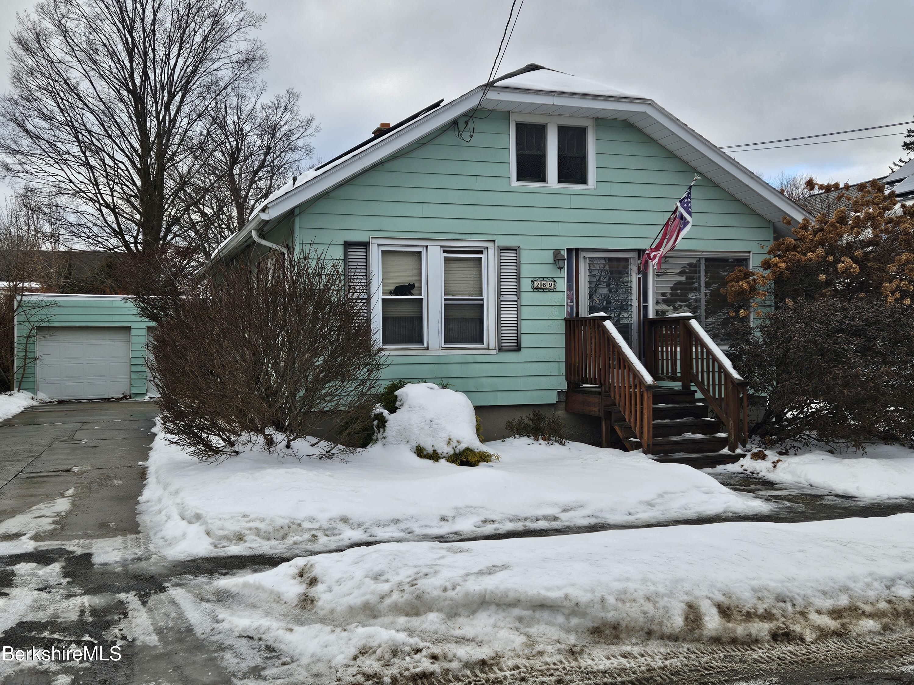 a view of a house with a yard covered in snow