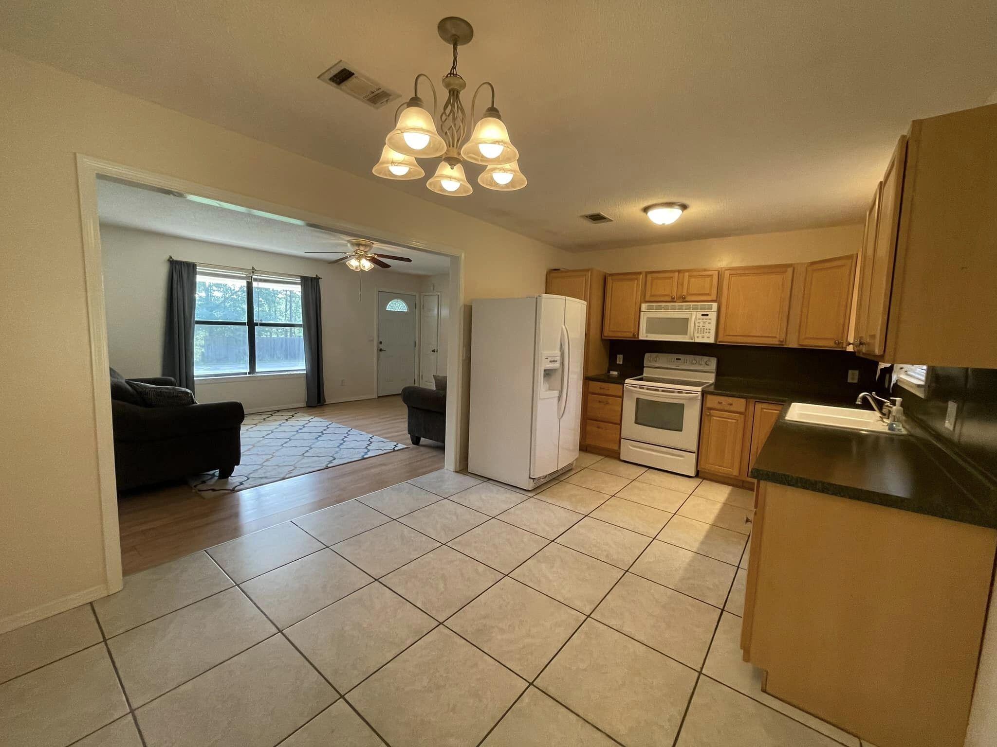 688 Roberts Drive DeFuniak Springs, FL 32433 - Photo 3 of 19 a large kitchen with kitchen island granite countertop a sink cabinets and stainless steel appliances