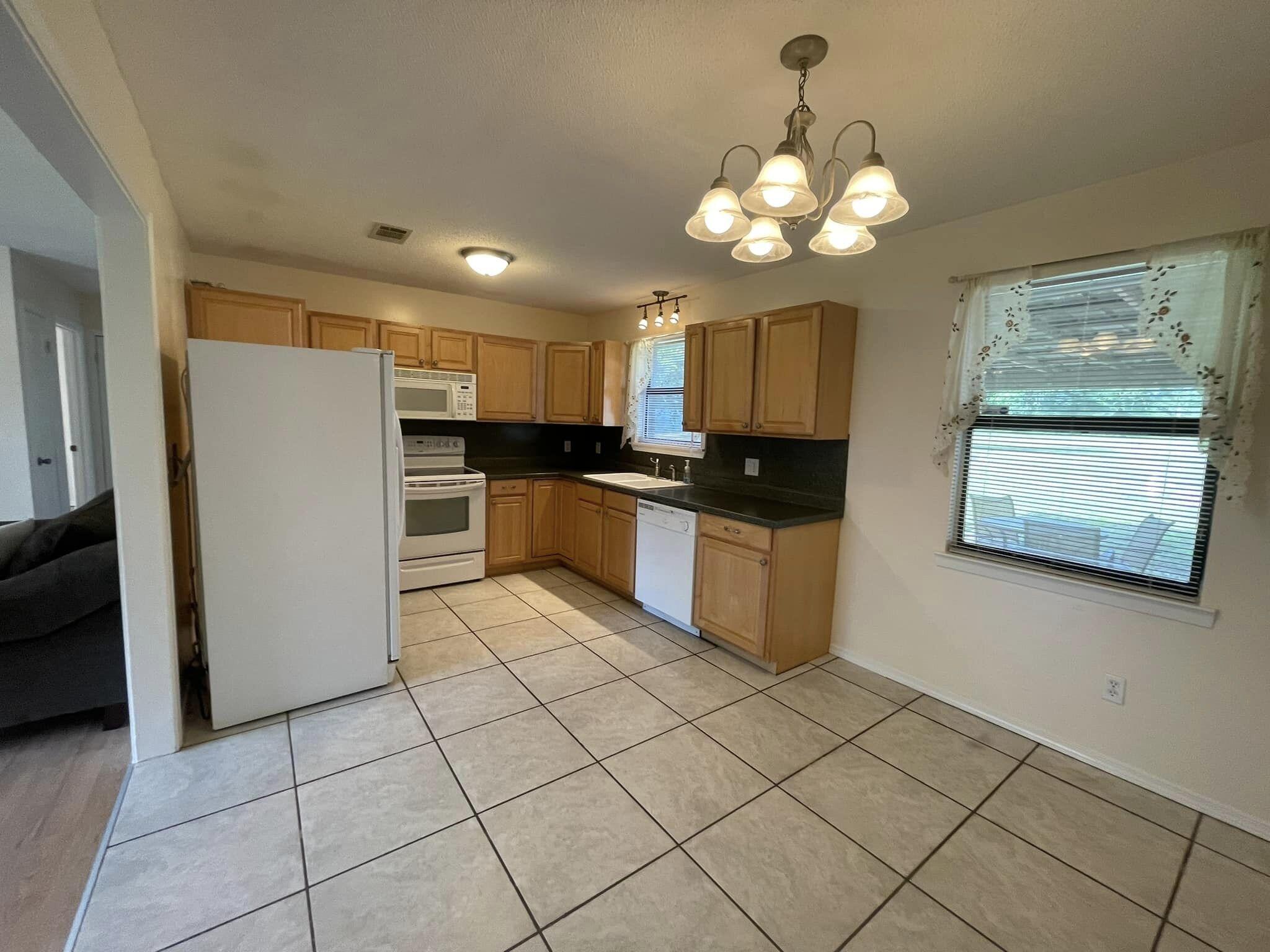 688 Roberts Drive DeFuniak Springs, FL 32433 - Photo 4 of 19 a kitchen with stainless steel appliances granite countertop a refrigerator and a stove top oven