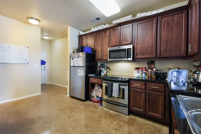 a kitchen with stainless steel appliances granite countertop a refrigerator stove and sink