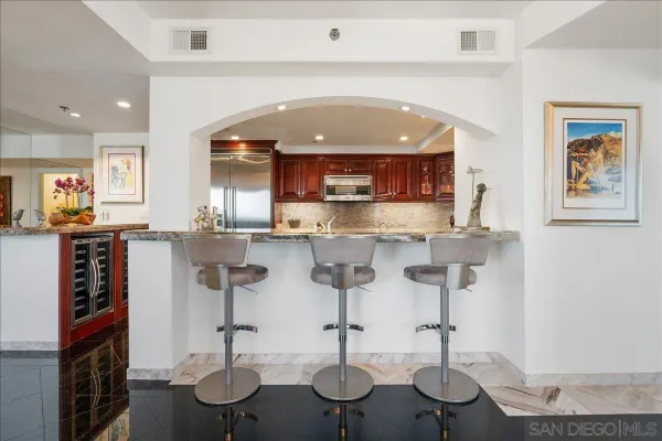 a kitchen with stainless steel appliances kitchen island granite countertop a table and chairs in it