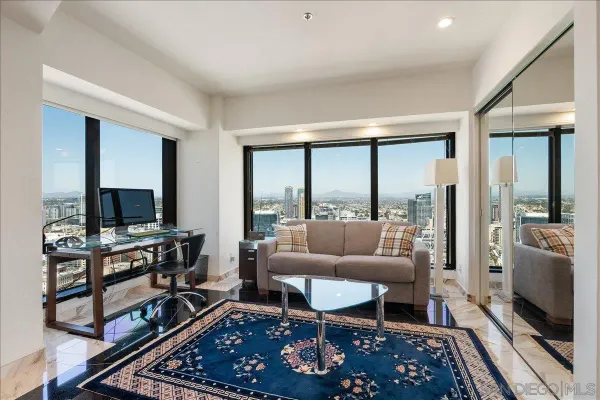a living room with furniture a flat screen tv and a floor to ceiling window