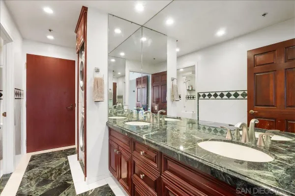 a bathroom with double vanity and a mirror