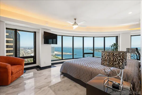 a spacious bedroom with a bed a couch and a large window