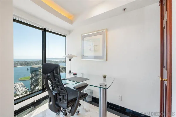 a view of a workspace with furniture and a window