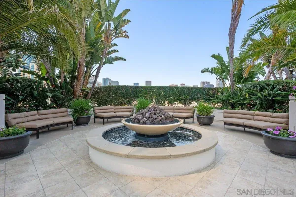 a view of a backyard with table and chairs potted plants and a fire pit