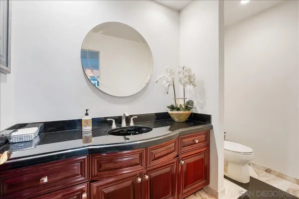 a bathroom with a granite countertop sink and a mirror
