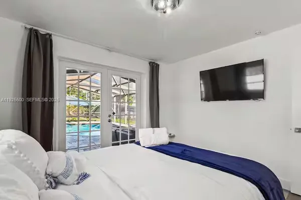a bedroom with a bed tv and a window