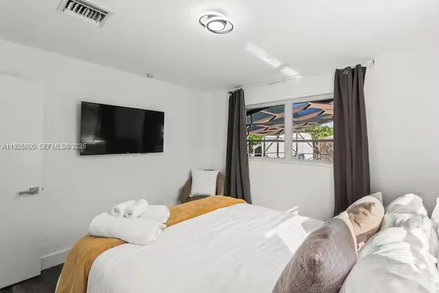 a bedroom with a bed and a flat screen tv