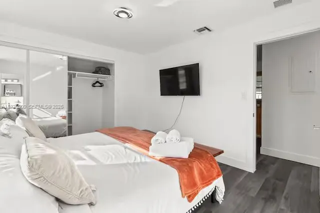 a bedroom with a bed and a flat screen tv