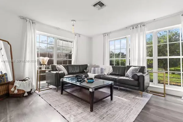 a living room with furniture and a floor to ceiling window