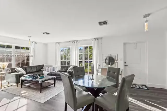 a view of a dining room with furniture and wooden floor