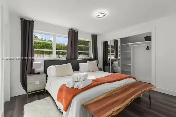 a bedroom with a bed and a large window
