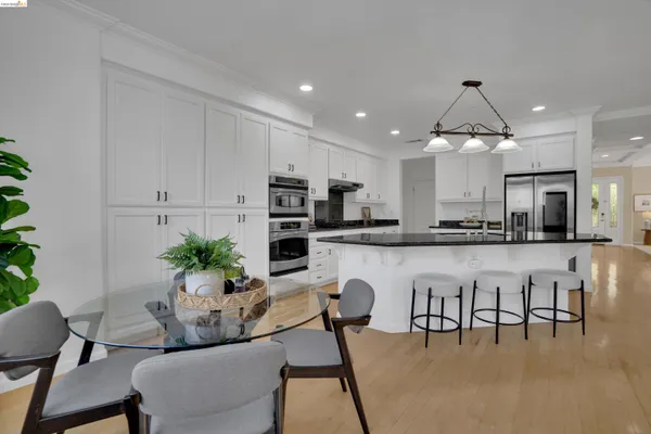 a dining room with furniture and kitchen view