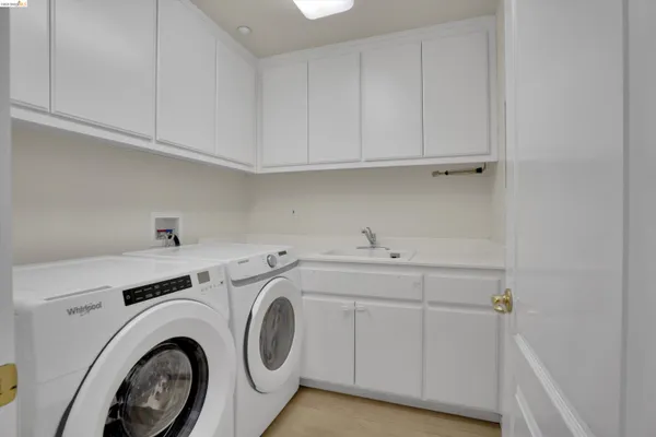 a utility room with sink dryer and washer