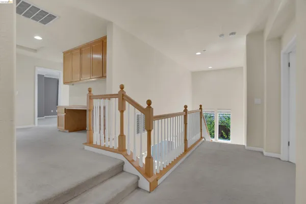 a view of a hallway with entryway to stairs