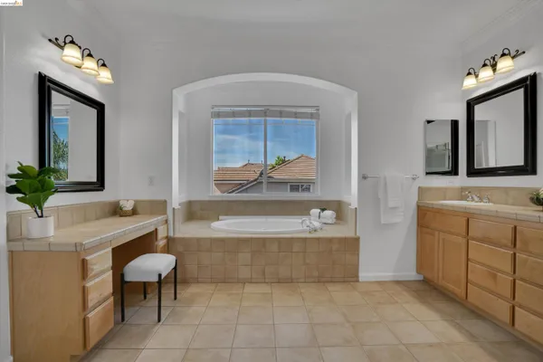 a bathroom with a tub sink and mirror