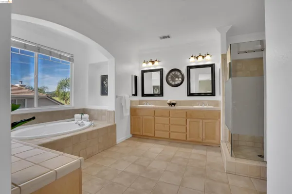 a spacious bathroom with a tub sink and mirror