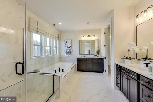 a spacious bathroom with a tub sink and mirror