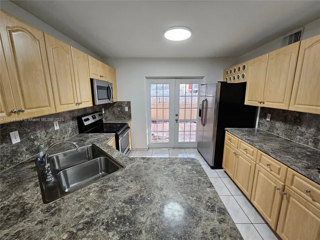 a kitchen with stainless steel appliances granite countertop a stove a sink and a microwave