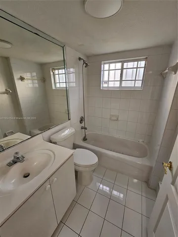 a bathroom with a granite countertop sink a toilet a mirror and shower