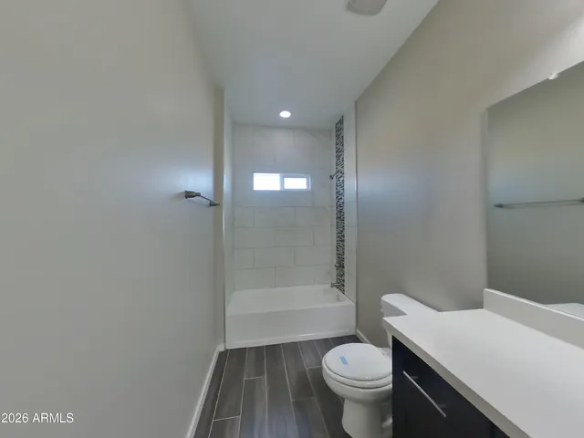 a bathroom with a granite countertop toilet a sink and shower
