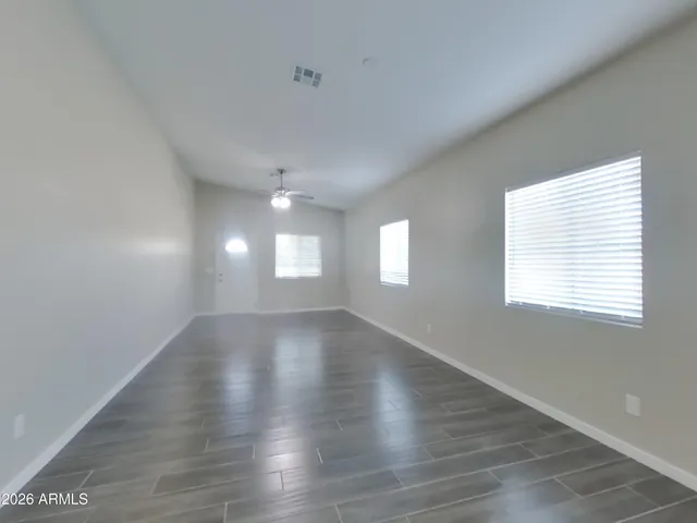 a view of empty room with wooden floor and window
