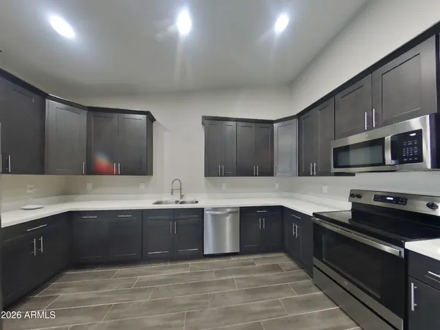 a kitchen with granite countertop stainless steel appliances and wooden cabinets