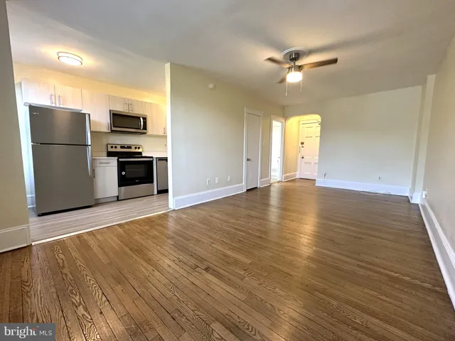 a view of a kitchen with a refrigerator a stove top oven and cabinets