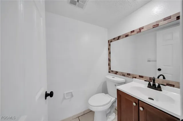 a bathroom with a sink mirror vanity and toilet